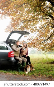 Senior Couple With Dogs Sharing Coffee From Car Boot, Norfolk, UK