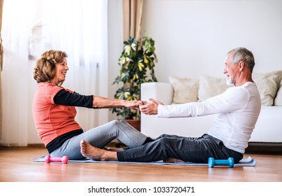 Senior Couple Doing Exercise At Home.