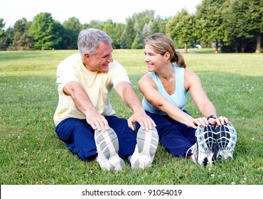 Senior couple doing yoga in the park.