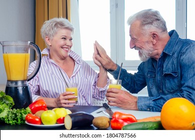 Senior couple drinking vegan smoothie with organic fruits and vegatables from eco glasses and reusable tubes,high five - Powered by Shutterstock