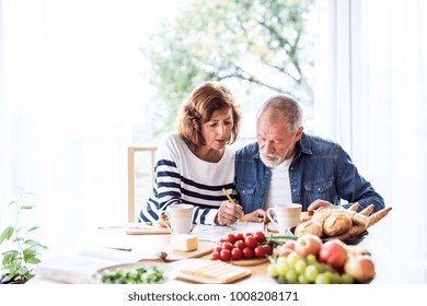 Senior couple eating breakfast at home.