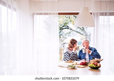 Senior Couple Eating Breakfast At Home.