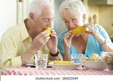 Senior Couple Eating Meal Together In Kitchen