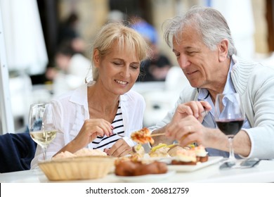 Senior couple eating Spanish fingerfood in Spain