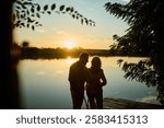 Senior couple embraces on a pier at sunset, enjoying the tranquil lake view. The romantic scene evokes peace, love, and happiness in their golden years