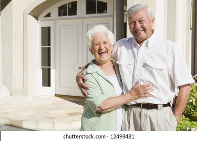 Senior Couple Embracing Outside House