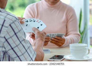 senior couple enjoy playing cards game together, concept elderly pensioner lifestyle, entertainment, recreation, encourages social interaction, help memory retention 