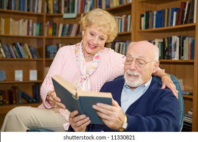 Senior couple enjoying a good book together in the library.