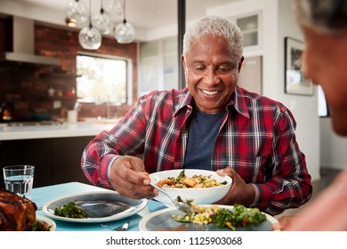 Senior Couple Enjoying Meal Around Table At Home