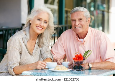 Senior Couple Enjoying Snack At Outdoor Cafe - Powered by Shutterstock