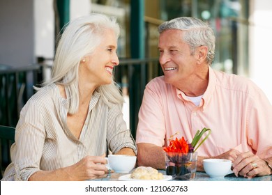 Senior Couple Enjoying Snack At Outdoor Cafe