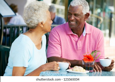 Senior Couple Enjoying Snack At Outdoor Cafe