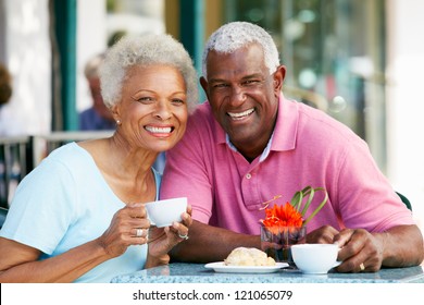 Senior Couple Enjoying Snack At Outdoor Cafe