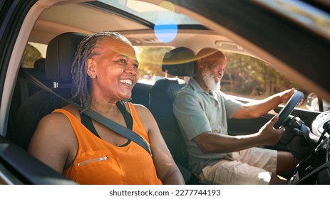 Senior Couple Enjoying Summer Day Trip Out Driving In Car Together - Powered by Shutterstock