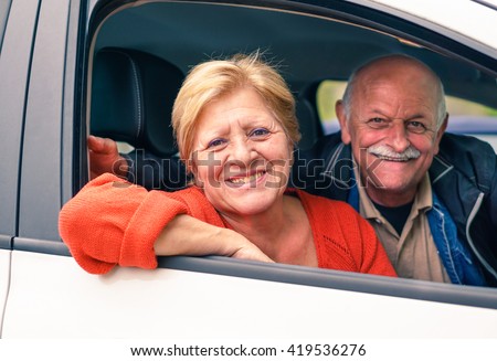 Senior couple enjoying their new car - Happy people smiling during road trip vacation - Active elderly concept around the world - Focus on woman - Warm filtered look