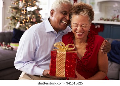 Senior Couple Exchanging Christmas Gifts At Home - Powered by Shutterstock