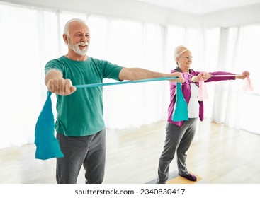 Senior couple exercise stretching and exercising with resistance band at home health care  - Powered by Shutterstock