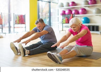 Senior Couple Exercising In Gym
