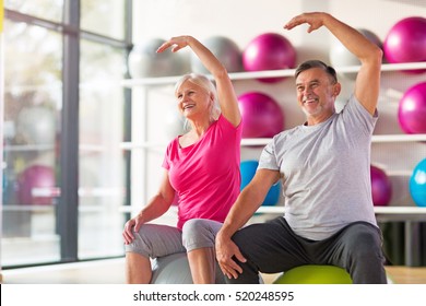 Senior Couple Exercising In Gym
