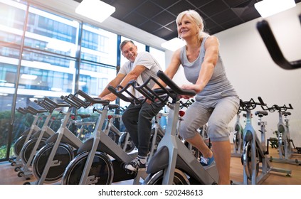 Senior Couple Exercising In Gym
