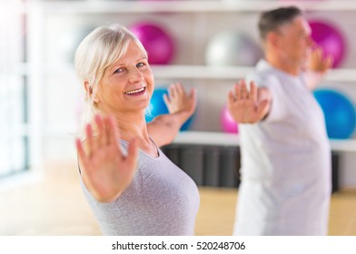 Senior Couple Exercising In Gym
