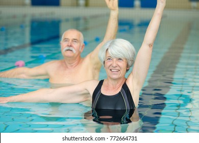 senior couple exercising in swimming pool - Powered by Shutterstock