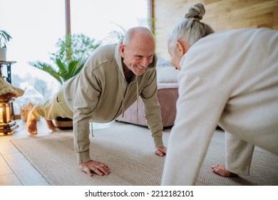 Senior couple exercising together in their living room during cold autumn day. - Powered by Shutterstock