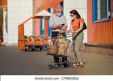 Senior couple with face masks and shopping walking outside supermarket       - Powered by Shutterstock