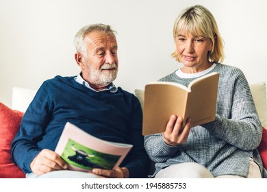 Senior Couple Family Relax Having Good Time Reading The Book Together.Happy Elderly Husband And Wife Reading News And Magazine While Sitting On Sofa At Home.Retirement Concept