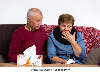 Senior Couple Is Fighting Disease At Home. The Elder Woman Coughing, Her Husband Is Caring For Her.