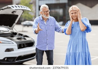 Senior couple fighting on road, have problems with car. Stressed elderly woman cover her ear while her angry husband yelling and gesturing. Spouses standing by broken auto hood on the street - Powered by Shutterstock