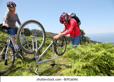 Senior Couple Fixing Broken Bicycle Chain