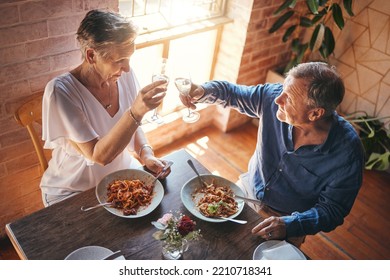 Senior couple, food and champagne in a restaurant while sharing a toast for celebration of love for an anniversary. Elderly man and woman with alcohol drink celebrating marriage eating pasta in Italy - Powered by Shutterstock