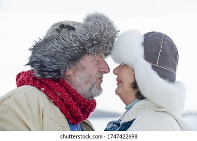 Senior couple in fur-trimmed hats touching noses - Powered by Shutterstock