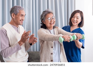 Senior couple get medical service visit from caregiver nurse at home while dumbbell exercising muscle strength in pension retirement center for rehabilitation and longevity post recovery process - Powered by Shutterstock