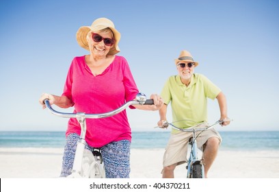 Senior Couple Going For A Bike Ride On The Beach