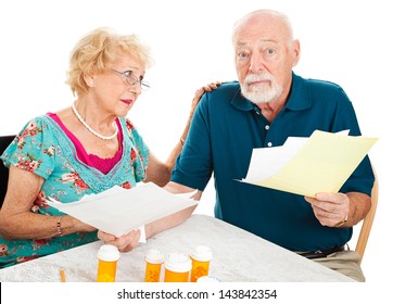 Senior Couple Going Over Their Medical Bills.  They Are Confused And Overwhelmed.  White Background.