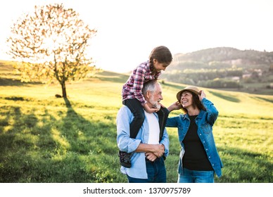 Senior Couple With Granddaughter Outside In Spring Nature, Having Fun.