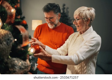 Senior couple happily decorates a christmas tree in their cozy home, radiating warmth and joy. Capturing the essence of togetherness and creating lasting memories during the holiday season - Powered by Shutterstock