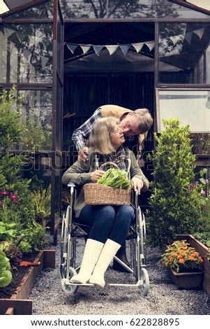 Similar – Woman carrying her mother in a wheelchair