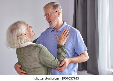 senior couple have fun dancing at home, romantic mature grey-haired man and woman feel energetic active enjoy family retirement weekend, spend holidays together