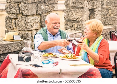 Senior Couple Having Fun Eating At Restaurant On Traveling - Mature Man And Woman Wife On Active Elderly Vacation - Happy Retirement Concept With Retired People Together - Warm Cloudy Day Color Tones