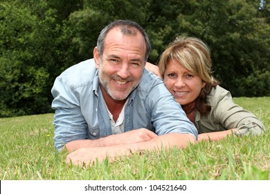 Senior Couple Having Fun Laying In Grass