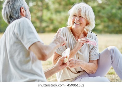 Senior Couple Having Fun And Playing A Card Game In Summer In The Nature