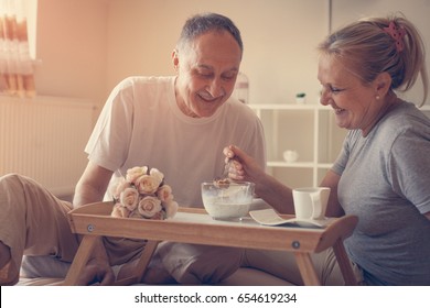 Senior couple having healthy breakfast together in bed.   - Powered by Shutterstock