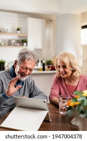 Senior Couple Having Video Call. Happy Husband And Wife Talking With Their Grandkids.