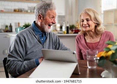 Senior Couple Having Video Call. Happy Husband And Wife Talking With Their Grandkids.