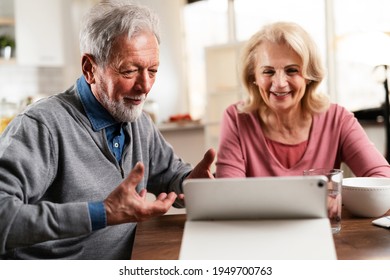 Senior Couple Having Video Call. Happy Husband And Wife Talking With Their Grandkids.