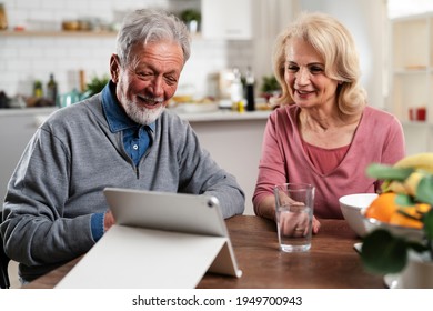 Senior Couple Having Video Call. Happy Husband And Wife Talking With Their Grandkids.