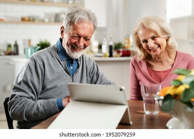 Senior Couple Having Video Call. Happy Husband And Wife Talking With Their Grandkids.